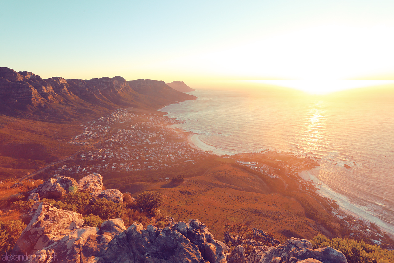 Simunye Sunset Foto von A breathtaking sunset over Lion's Head, Cape Town, where golden light dances on the ocean and rugged cliffs.