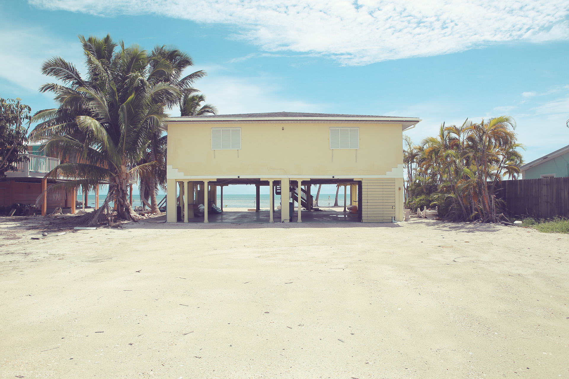 Keys' Coastal Dream Foto von A quaint stilt house stands before azure waves and swaying palms in Monroe County, Florida, epitomizing tranquil coastal living.