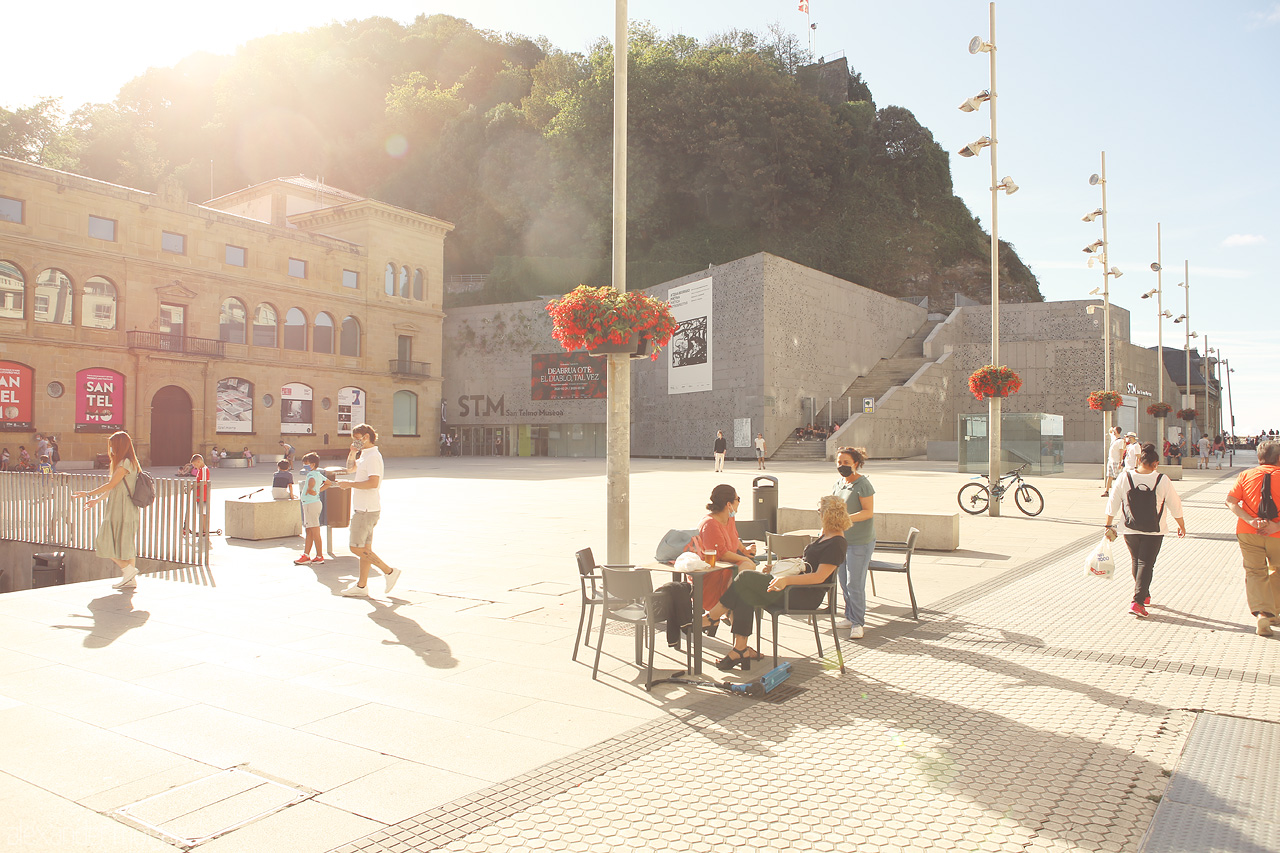 Donostia Dusk Moments Foto von A serene San Sebastián plaza basks in golden sunlight, locals enjoying relaxed outdoor conversations.
