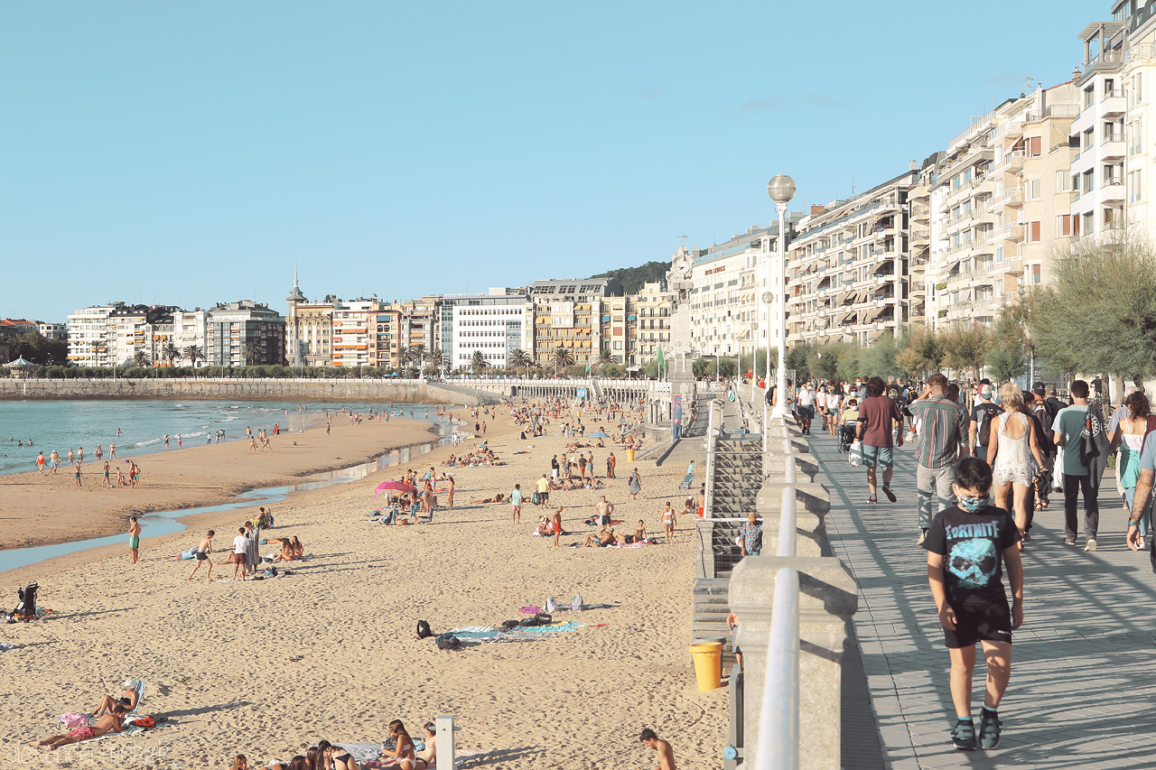 La Concha's Hush Foto von A serene day wanes on San Sebastián's La Concha beach, with strolling visitors and sun-kissed sands.