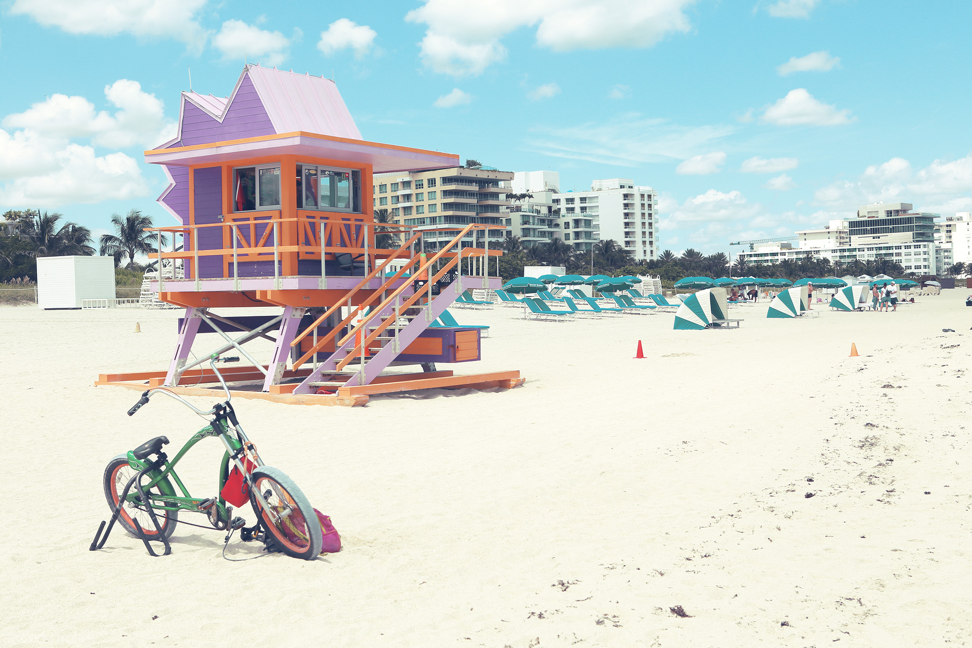 Pastel Paradise Foto von A vibrant lifeguard tower and cruiser bike on Miami's iconic South Beach under a cloud-swept sky.