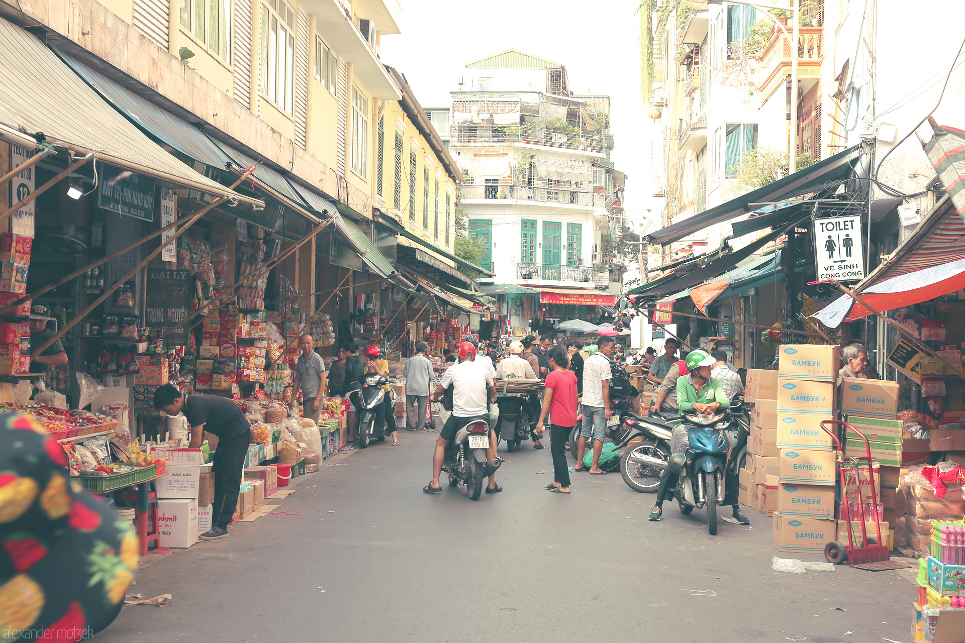 Foto von Bustling market life in Phuong Hàng Buom, Hanoi. Street vendors, scooters, and vibrant chaos captured in the Old Quarter.