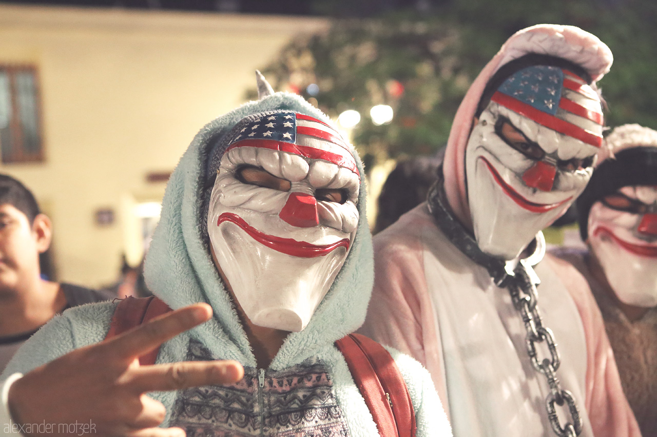 Máscaras Oaxaqueñas Foto von Colorful masked figures at a night festival for the dia de los muertos in Oaxaca de Juárez, evoking local tradition.