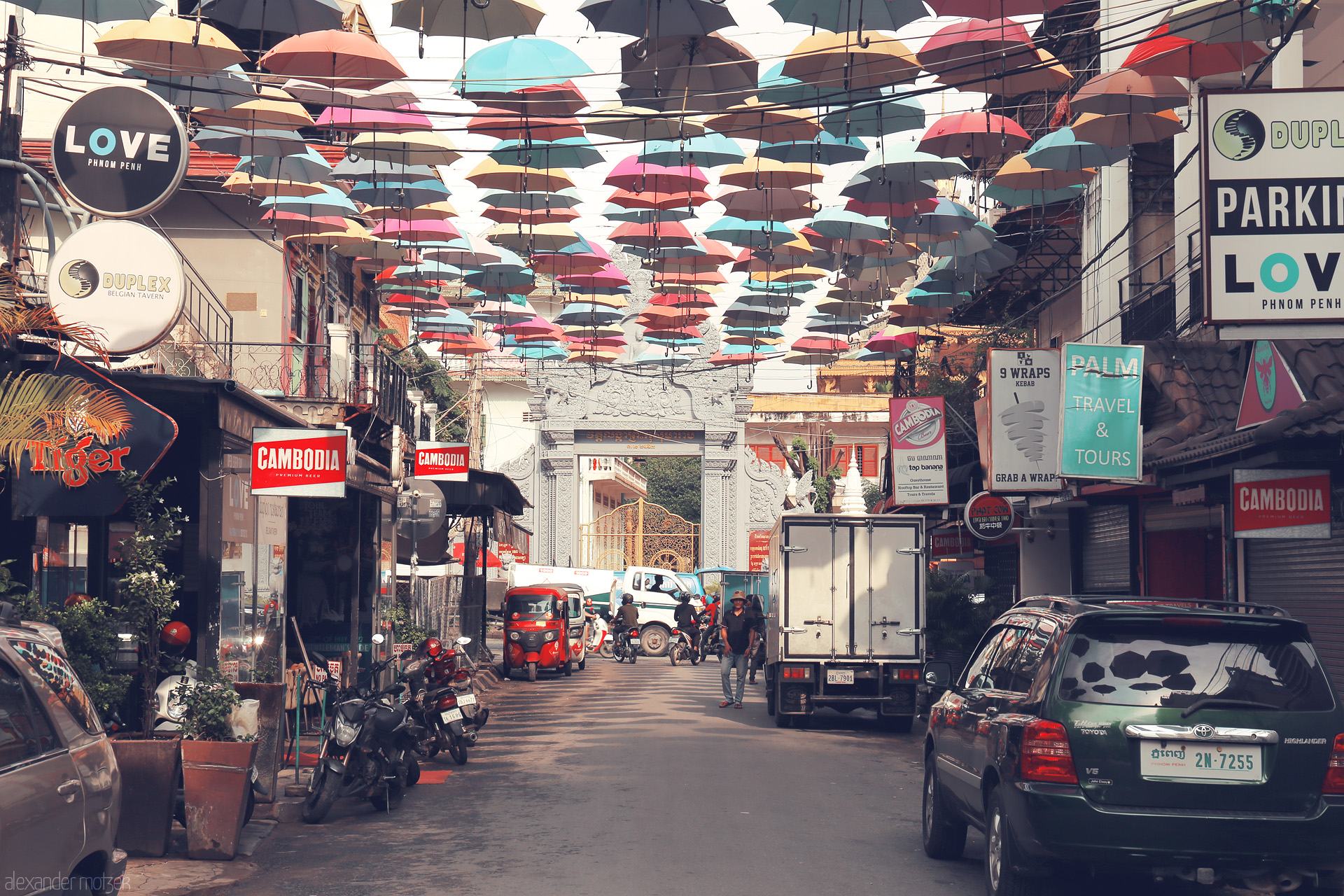 Foto von Colorful umbrellas float above a lively Phnom Penh street, blending Khmer spirit with urban bustle beneath the tropical sky.