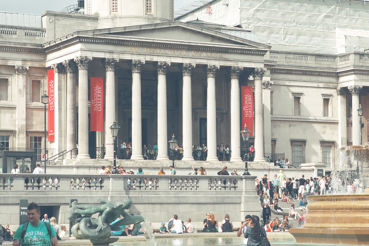 Trafalgar Revived Foto von Crowds gather at Trafalgar Square, soaking in the culture and history of London amidst the iconic columns of the National Gallery.