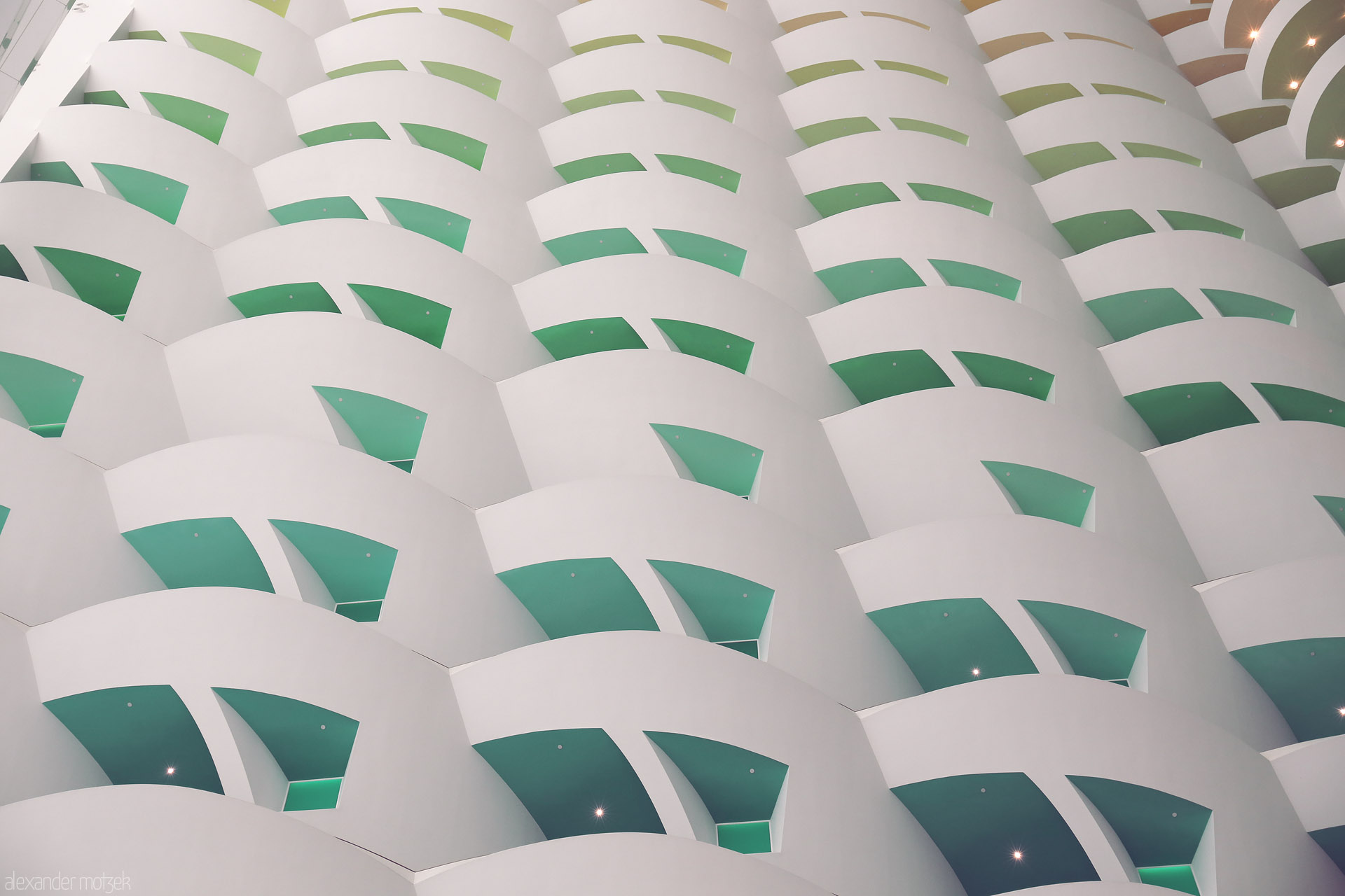 Foto von Curved white balconies with green reveals mimic waves—modern Dubai architecture echoing desert tradition, United Arab Emirates.