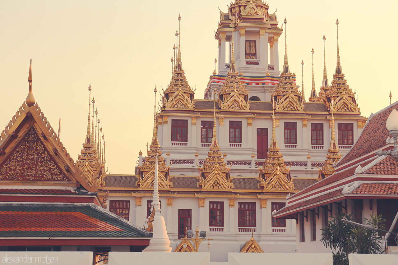 Golden Serenity in Ban Phan Thom Foto von Discover the golden spires of Ban Phan Thom in Bangkok, where ornate details meet serene skies in a breathtaking architectural vista.