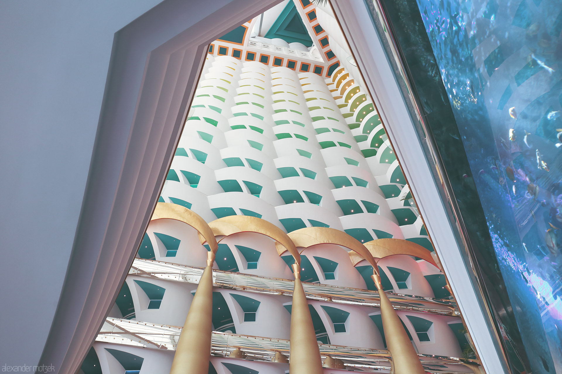 Opulence Ascends Foto von Gilded columns and teal balconies spiral upward inside Dubai's iconic Burj Al Arab, capturing the spirit of luxury and Arabian design.