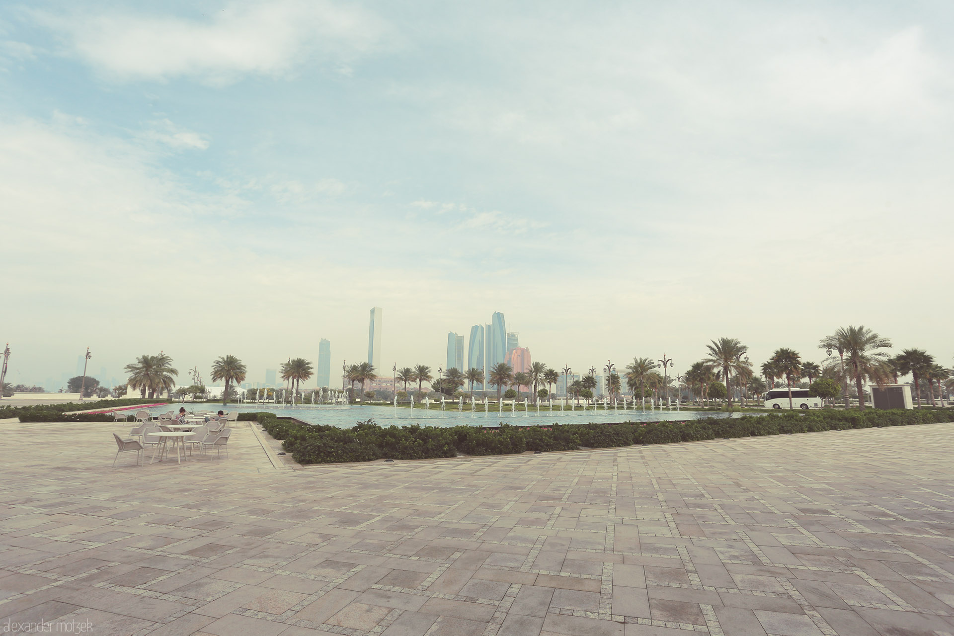 Khaleej Tranquility Foto von Palm-lined fountains meet Abu Dhabi’s skyline in Al Ras Al Akhdar, where calm meets cosmopolitan beneath a pastel Gulf sky.