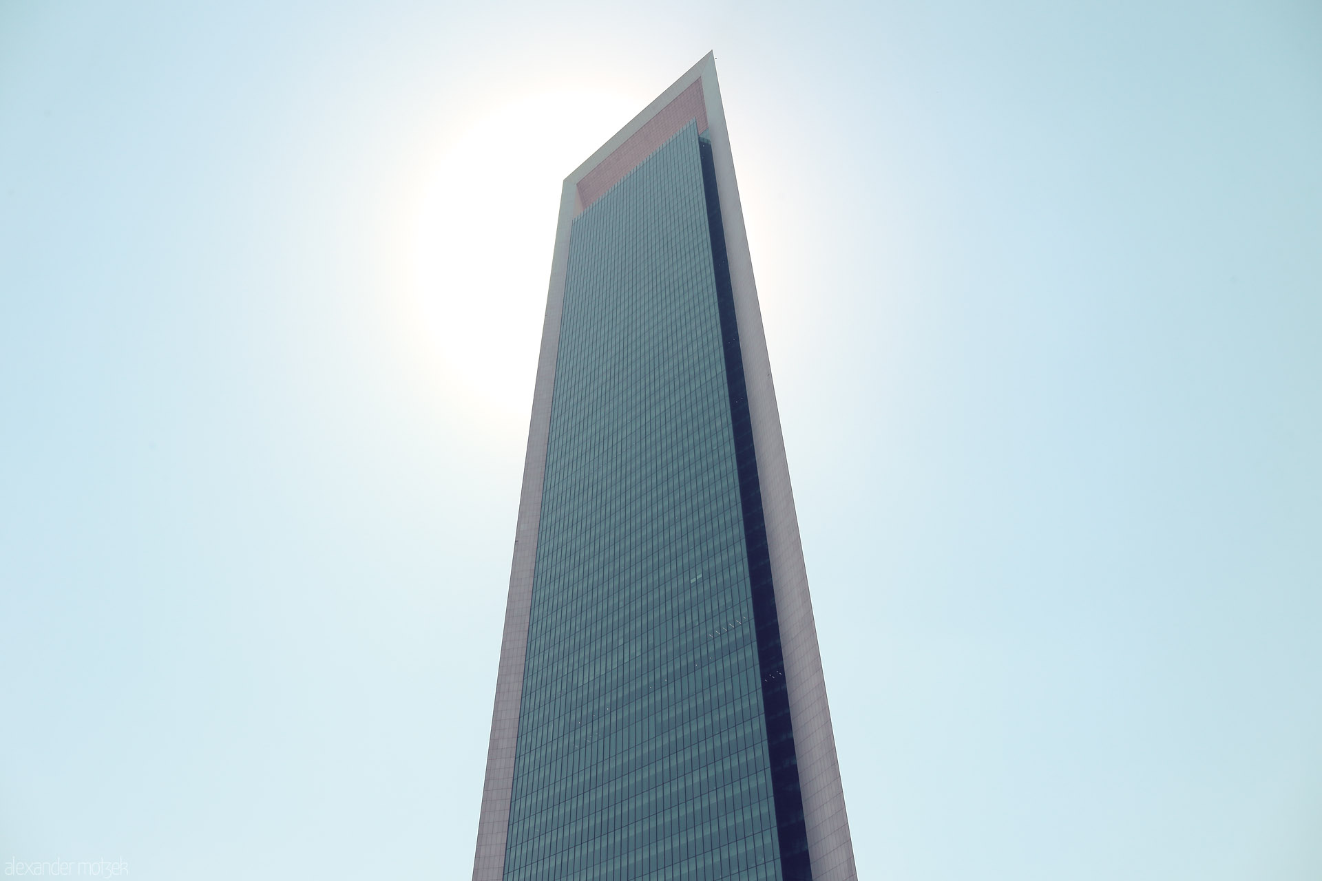 Foto von The sun crowns ADNOC HQ in Al Ras Al Akhdar, Abu Dhabi, capturing modern grandeur against a cloudless Gulf sky.