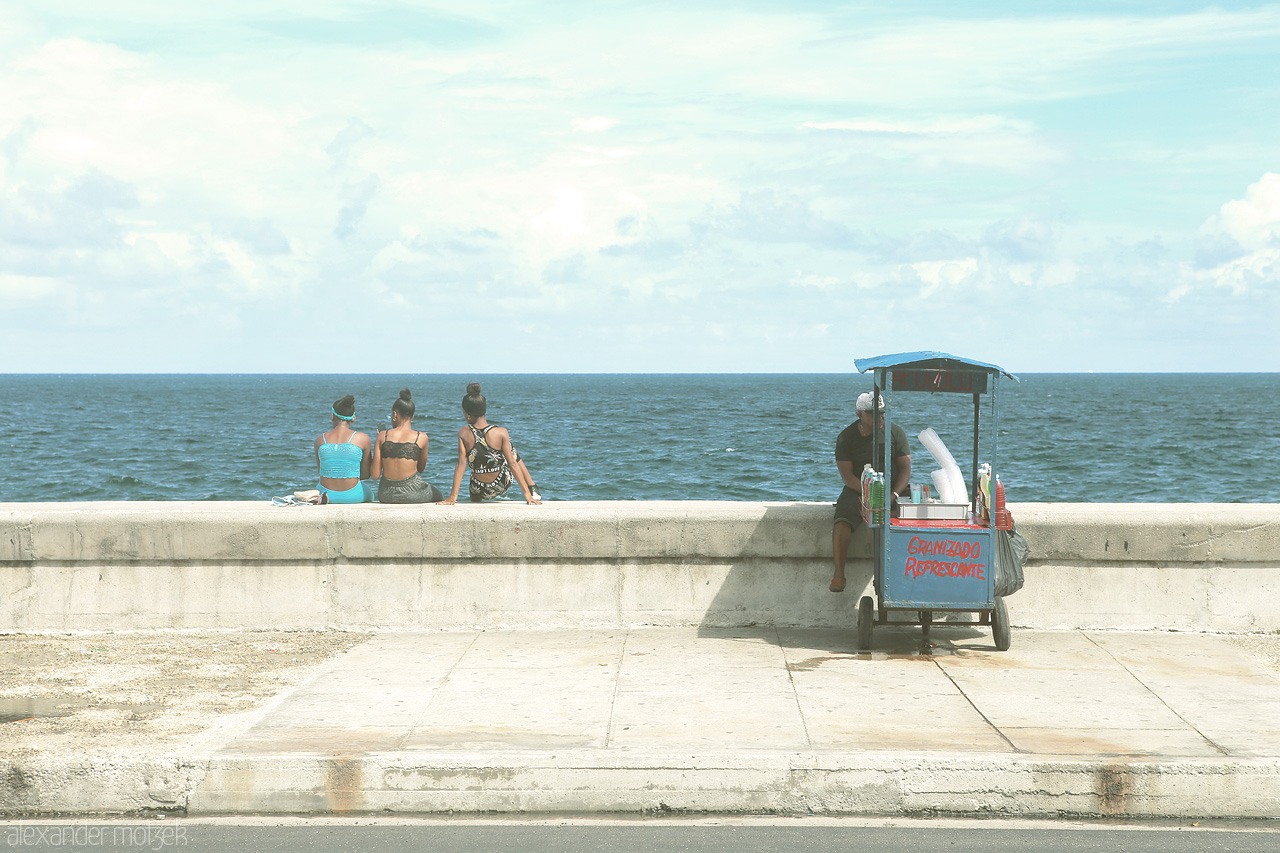 Malecón Foto von Frauen sitzen auf der Ufermauer entlang des Malecón in Havana
