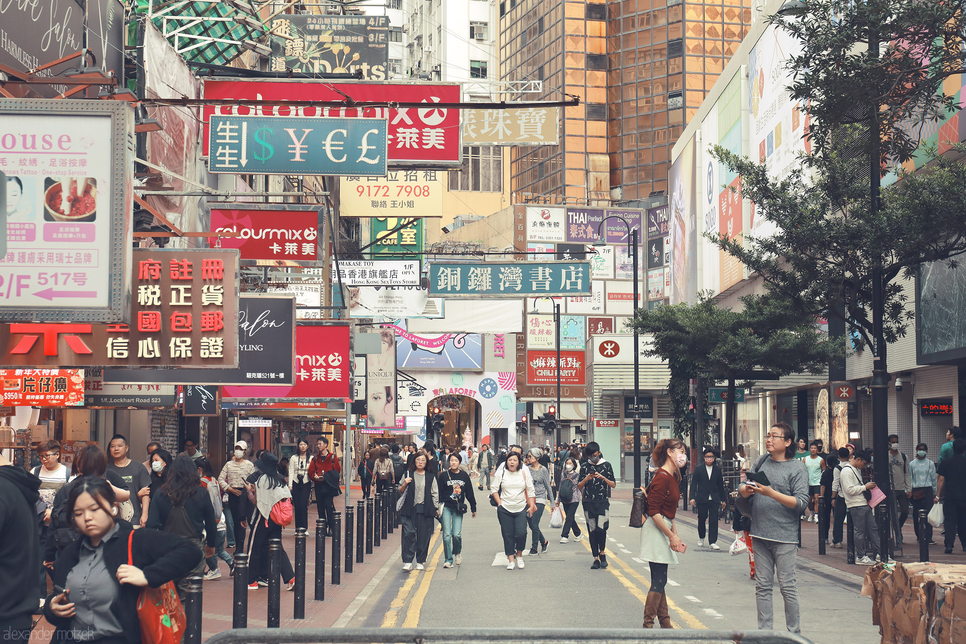 Foto von Crowded Lockhart Road in Wan Chai, Hong Kong—pedestrians under a canopy of Chinese shop signs and soft neon city haze.