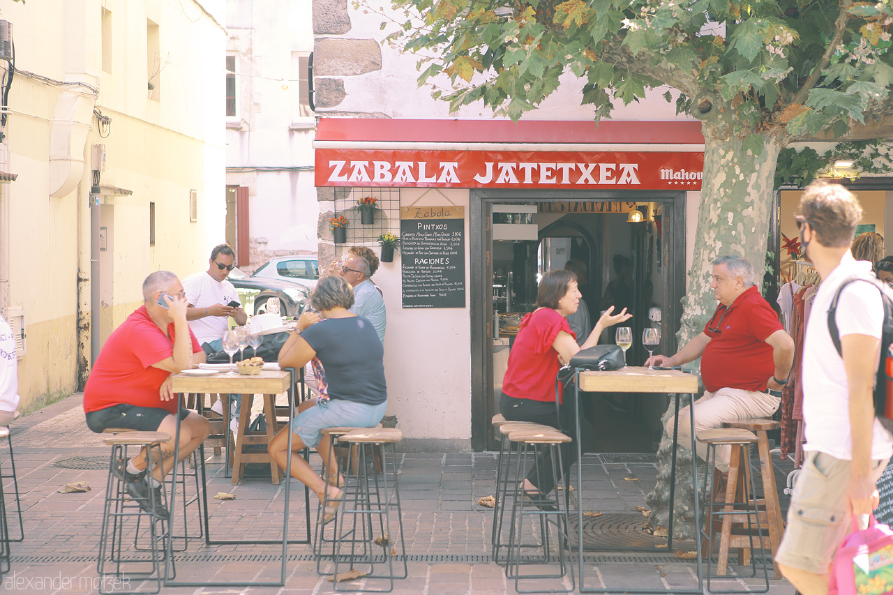 Zabalaren Zirrara Foto von Lively street dining scene outside 'Zabala Jatetxea' in Hondarribia, capturing the essence of Basque conviviality.