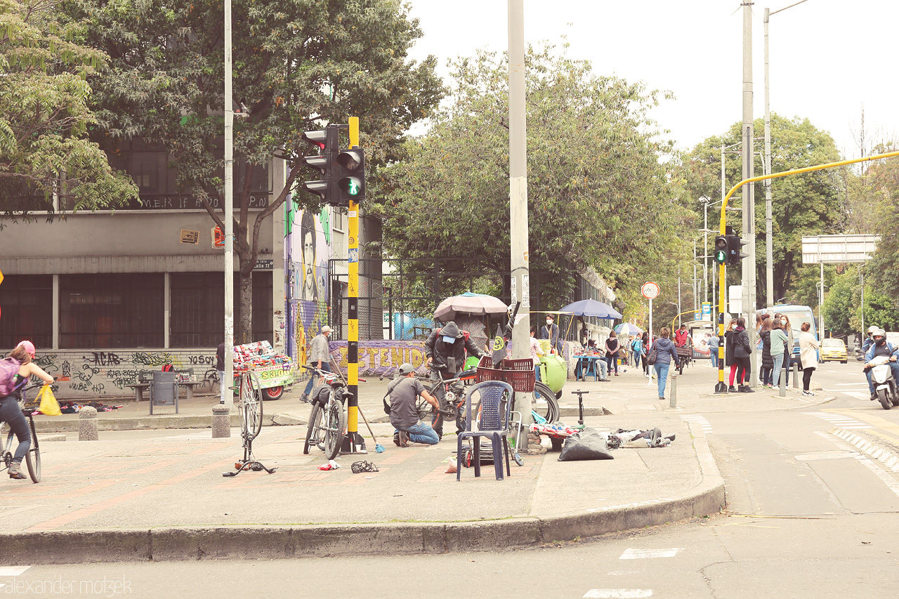 CicloRescate Chapinero Foto von Locals repair bikes on the streets of Chapinero, Bogota, Colombia, capturing the essence of community and urban life.