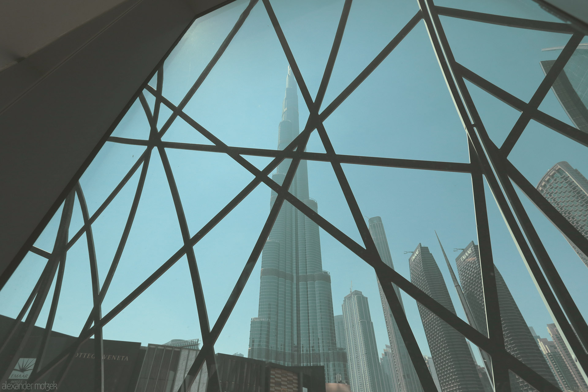 Foto von The iconic Burj Khalifa rises behind a geometric window, blending tradition and modernity in Dubai, UAE.