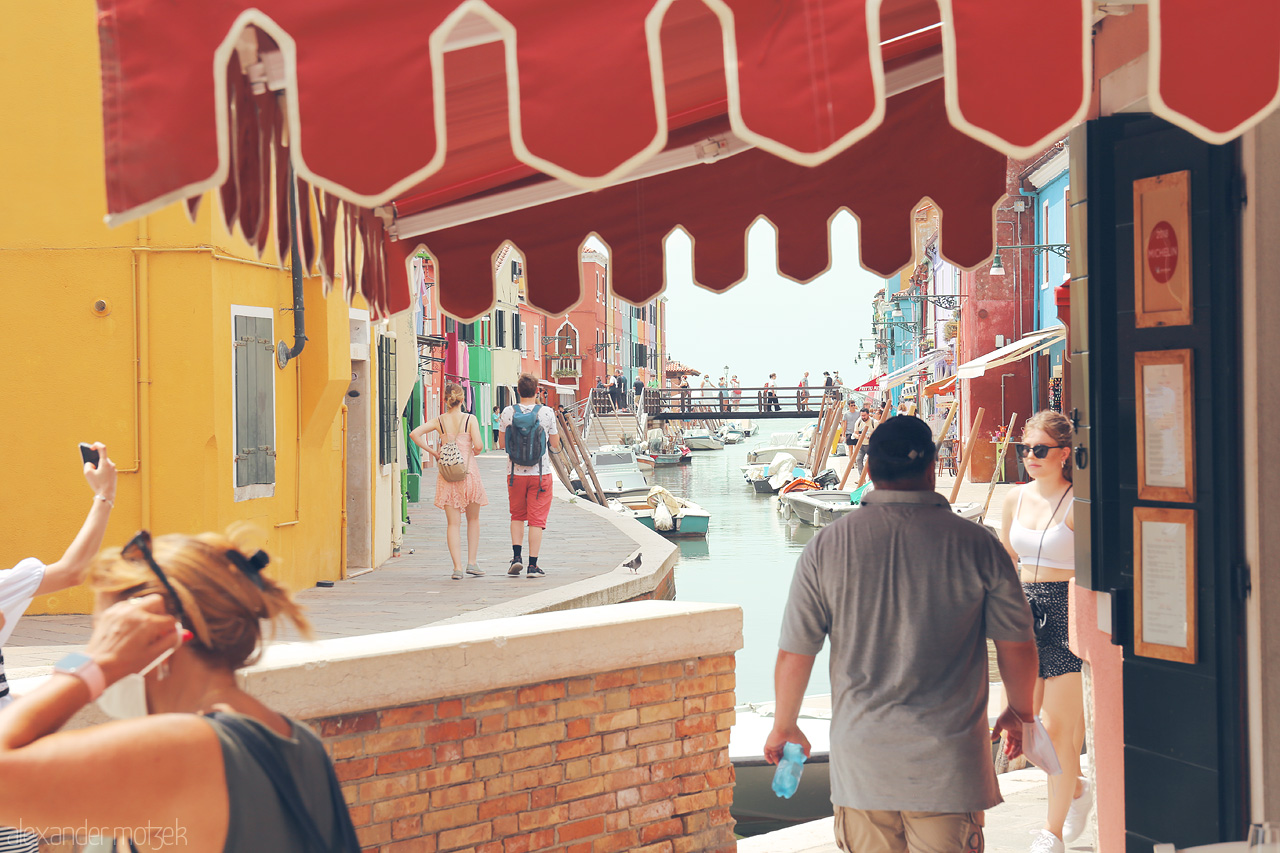 Burano's Palette Foto von Vibrant canal life under Venetian sun, with colorful facades and leisurely strolls.